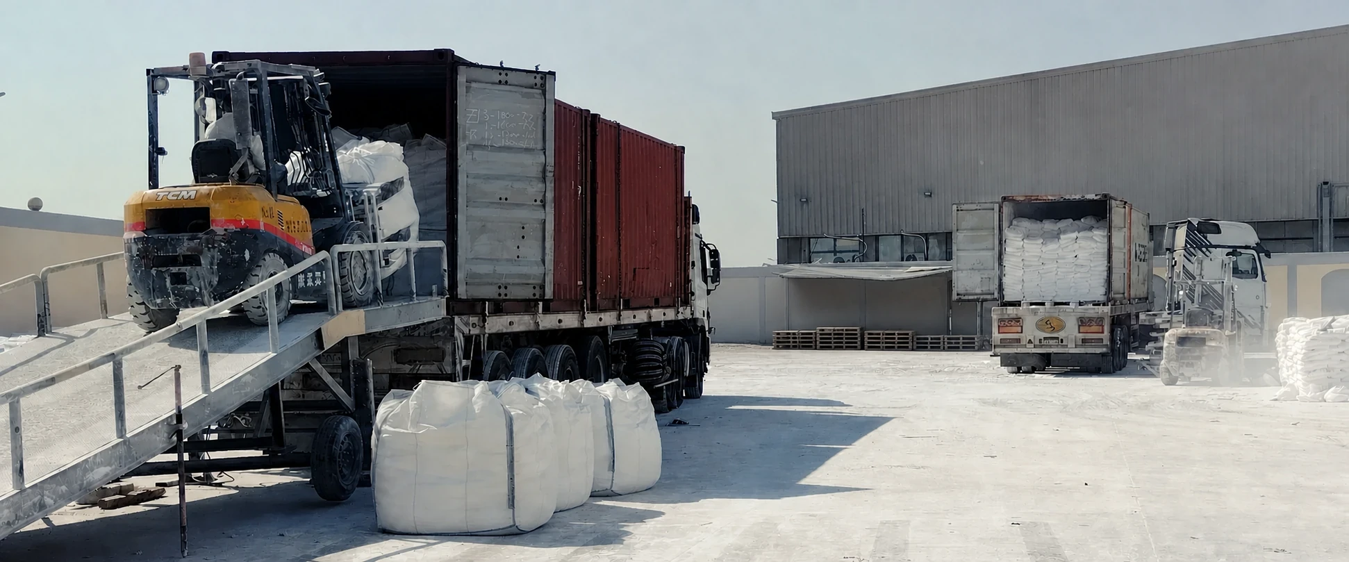 Forklift loading calcium carbonate FIBC jumbo bags into a shipping container at our plant
